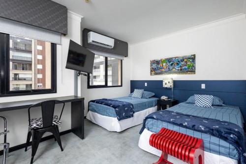 a bedroom with two beds and a flat screen tv at LFlats no Hotel Aeroporto Congonhas in São Paulo
