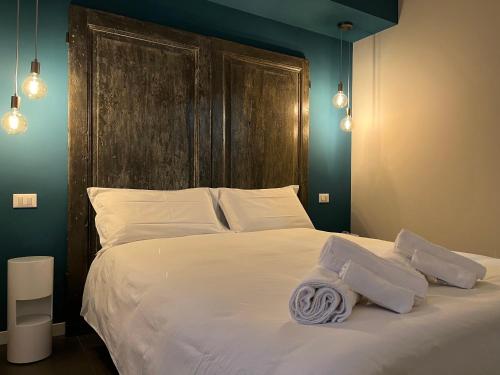 a bedroom with a large white bed with a wooden headboard at Ca'Sazen Trilo 19 in Brescia