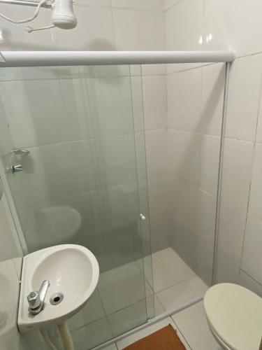 a bathroom with a glass shower and a sink at Pousada nascente do sol in Macaé
