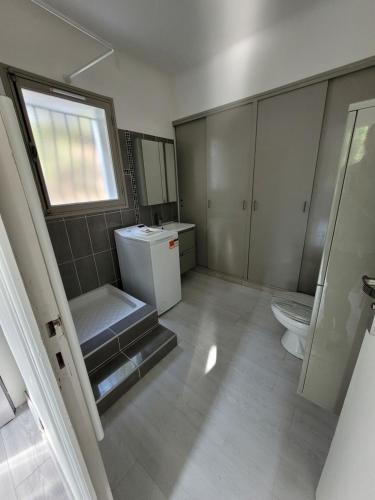 a bathroom with a toilet and a sink and a window at Studio lit double. in Gréoux-les-Bains