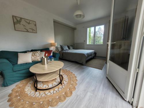 ein Wohnzimmer mit einem Sofa und einem Tisch in der Unterkunft Studio lit double. in Gréoux-les-Bains