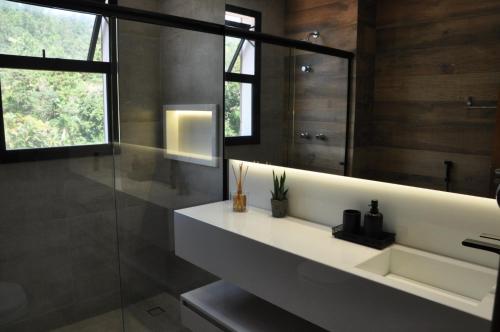 a bathroom with a sink and a mirror at Apartamento Alto Padrão Ubatuba in Ubatuba