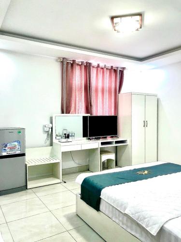 a bedroom with a bed and a desk with a television at Holiday Hotel 2 in An Khê