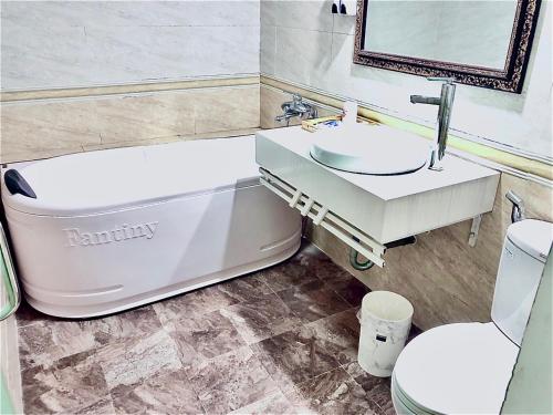 a bathroom with a bath tub and a sink and a toilet at Holiday Hotel 2 in An Khê