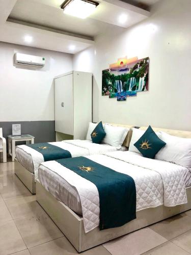 a bedroom with two beds with blue and white sheets at Holiday Hotel 2 in An Khê