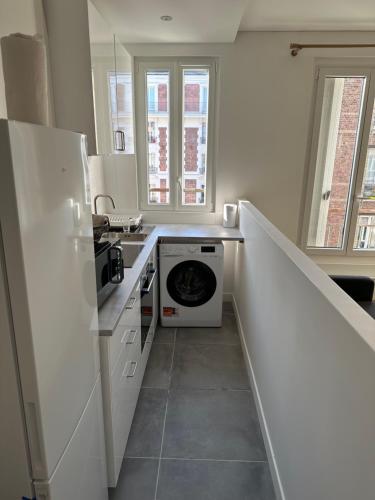 une cuisine avec un évier et une machine à laver dans l'établissement La Résidence élégante, à Saint-Denis