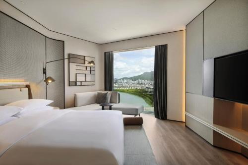 台州市にあるSheraton Taizhouのベッド1台、薄型テレビが備わるホテルルームです。