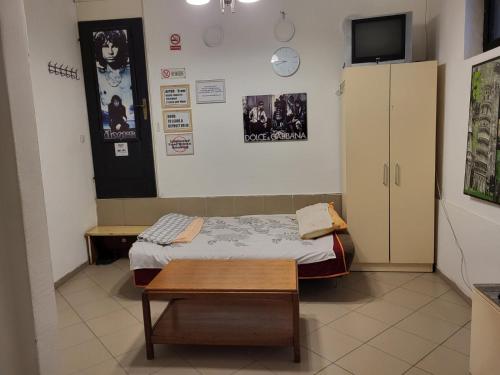 a small room with a bed and a table at Studio Centar - Ekonomy in Mitrovicë
