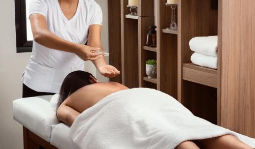 a woman getting a massage in a hotel room at Palmetto Hotel Business San Miguel in Lima