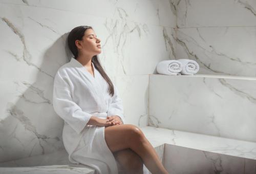 a woman sitting in a bath tub in a bathroom at Palmetto Hotel Business San Miguel in Lima