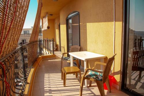 - un balcon avec une table et des chaises dans un bâtiment dans l'établissement 2BD Cosy Apartment with Spacious Balcony - Close to Bugibba Beach, à San Pawl il-Baħar