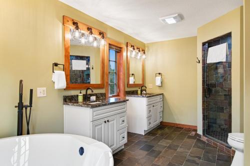 een badkamer met 2 wastafels, een bad en een douche bij Copperwood 5 in Eagle River