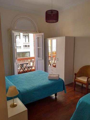 1 dormitorio con cama azul y balcón en Old town Santa Cruz, en Santa Cruz de Tenerife