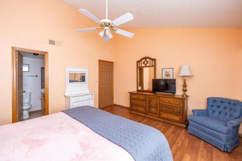 a bedroom with a bed and a tv and a chair at Bear Paw Condo in Flagstaff