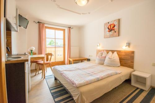 ein Schlafzimmer mit einem Bett und einem Schreibtisch sowie eine Küche in der Unterkunft Haus Schönblick in Kirchberg in Tirol