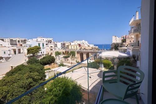 a balcony with a view of a city and the ocean at White Coast in Polignano a Mare