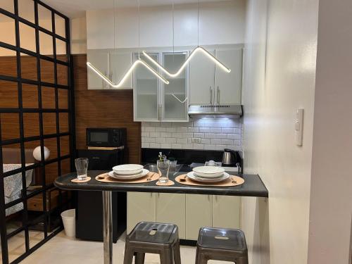 uma cozinha com uma mesa com pratos e copos em Morgan Suites Executive Residences em Manila