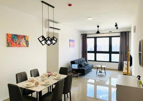 a dining room and living room with a table and chairs at 4BR M Vertica near Sunway Velocity Cheras IKEA MRT TRX KLCC Pavilion in Kuala Lumpur