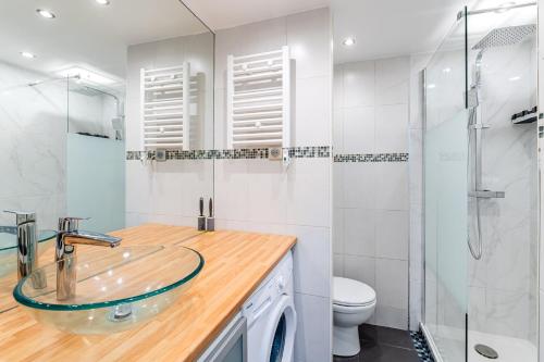La salle de bains est pourvue d'un lavabo en verre et d'une douche. dans l'établissement Vieux-Port: Climatisé + Balcon, à Marseille