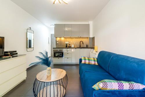 un salon avec un canapé bleu et une cuisine dans l'établissement Vieux-Port: Climatisé + Balcon, à Marseille