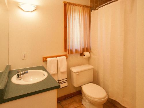 La salle de bains est pourvue de toilettes blanches et d'un lavabo. dans l'établissement Kilomètre 42, à Val-David