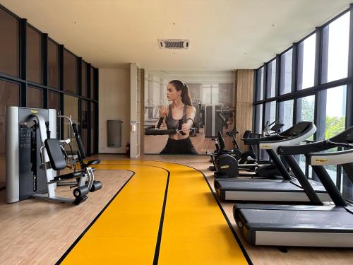 a woman standing in a gym with cardio equipment at 4BR M Vertica near Sunway Velocity Cheras IKEA MRT TRX KLCC Pavilion in Kuala Lumpur