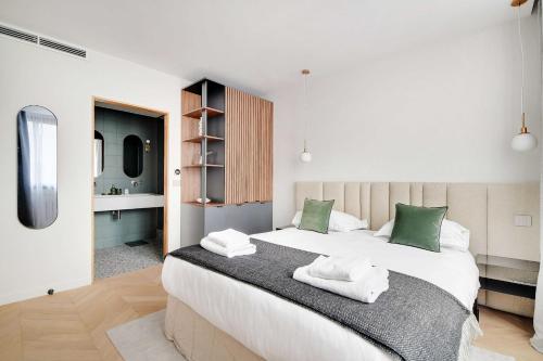 une chambre avec un grand lit blanc avec des oreillers verts dans l'établissement Cosy apartment 2BR-6P Champs Elysées, à Paris