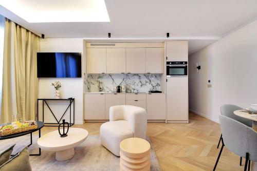 d'une cuisine et d'un salon avec des placards blancs et une table. dans l'établissement Cosy apartment 2BR-6P Champs Elysées, à Paris