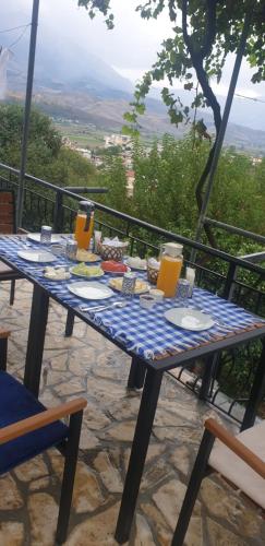 einen Tisch mit Teller mit Lebensmitteln und Orangensaft darauf in der Unterkunft Hazmurat Hotel in Gjirokastër