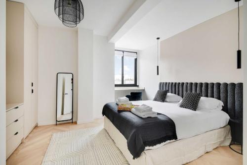 une chambre avec un grand lit et un miroir dans l'établissement Cosy apartment 2BR-6P Champs Elysées, à Paris