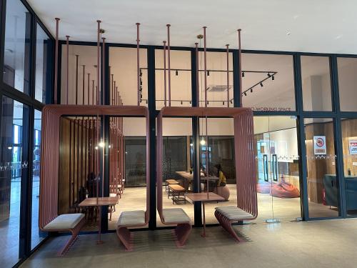 a lobby with tables and chairs in a building at 4BR M Vertica near Sunway Velocity Cheras IKEA MRT TRX KLCC Pavilion in Kuala Lumpur