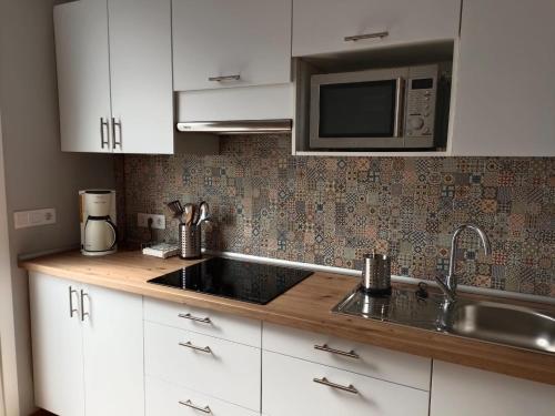 a kitchen with a sink and a microwave at Areas Negras. Casas de Fanego. in Cariño