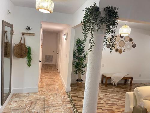 a living room with plants on the walls and a column at House of the statue of Adrianne in Tampa