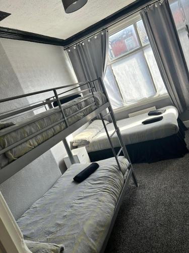 a bedroom with two bunk beds and a window at Adina Hotel in Blackpool
