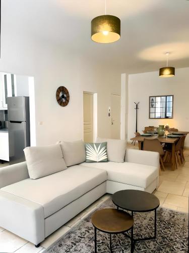 un salon avec un canapé blanc et une table dans l'établissement Grand T3 rénové climatisé - Coeur de Montpellier, à Montpellier