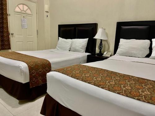 ein Hotelzimmer mit 2 Betten und einer Lampe in der Unterkunft He Centro - Desayuno incluido in Tuxtla Gutiérrez