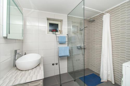 uma casa de banho com uma cabina de duche em vidro e um lavatório. em Apartment Lavanda em Kruševo