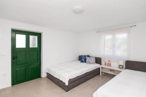 um quarto com 2 camas e uma porta verde em Apartment Lavanda em Kruševo
