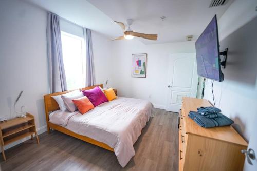 a bedroom with a bed with colorful pillows on it at ORLANDO - BLUE HERON Great Apt - 7 pax in Orlando