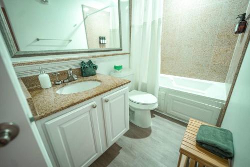a bathroom with a sink and a toilet and a mirror at ORLANDO - BLUE HERON Great Apt - 7 pax in Orlando