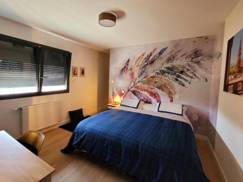 a bedroom with a blue bed with a painting on the wall at Villa Oriel 1 à NEUFCHATEL-HARDELOT avec piscine privée in Neufchâtel-Hardelot