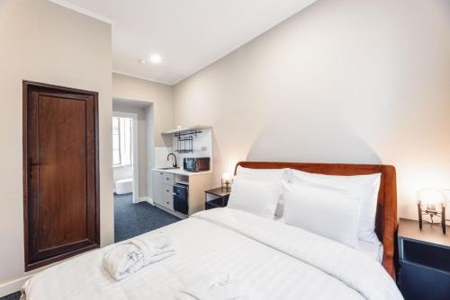 a bedroom with a large bed with white sheets at Salve in Tbilisi City