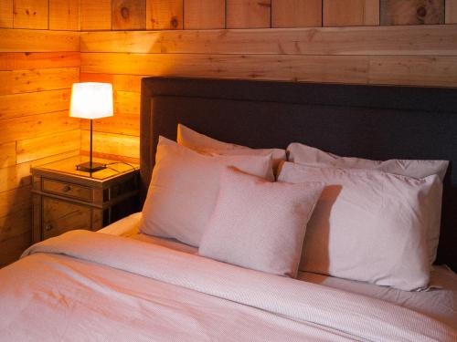 a bedroom with a bed with white pillows and a lamp at Chalet 8 in Val-David