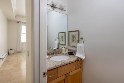 uma casa de banho com um lavatório e um espelho grande em Ocean View Del Mar Beach Home w Jacuzzi em San Diego