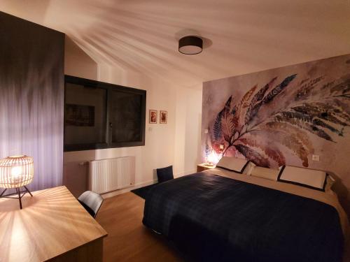 um quarto com uma cama e uma grande pintura na parede em Villa Oriel 1 à NEUFCHATEL-HARDELOT avec piscine privée em Neufchâtel-Hardelot