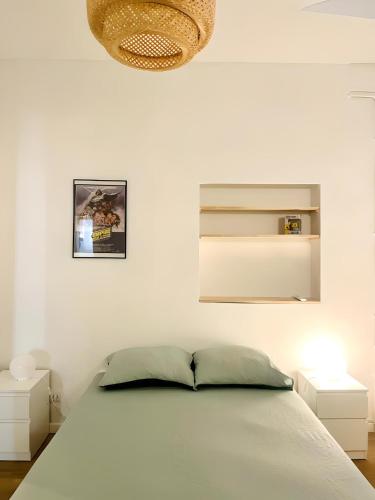 - une chambre blanche avec un lit et une lampe dans l'établissement Grand T3 rénové climatisé - Coeur de Montpellier, à Montpellier