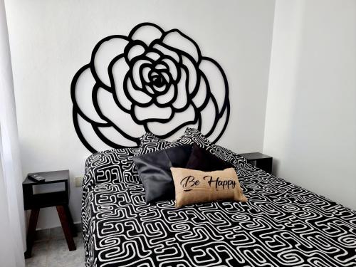 Un dormitorio con una cama con una flor. en Departamento ROSE en Caleta Olivia