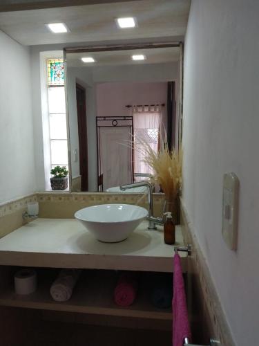 a bathroom with a sink and a large mirror at Cabañas Casa Flor Yacanto in Villa Yacanto