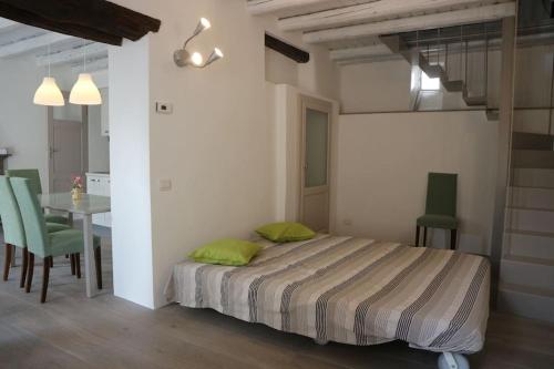 um quarto com uma cama, uma mesa e cadeiras em Traditional Piazza Home/Balcony/ Private Garden em Cernobbio
