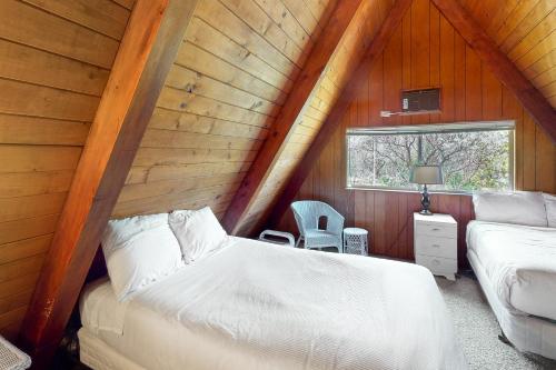 a attic bedroom with two beds and a window at Alford Family Lodge in Bass Lake